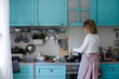 © LUMINA IMAGES - Back view of senior woman cooking spaghetti at home.