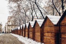 Wooden Cabins In Snow For Christmas Market. Snowy Town Square In Lviv. European City Preparing For Winter Christmas Holidays, Space For Text