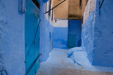 Traditional moroccan courtyard in Chefchaouen blue city medina in Morocco, architectural details in Blue town Chaouen. Typical blue walls and colorful flower pots.