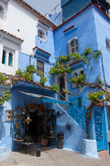 Traditional moroccan courtyard in Chefchaouen blue city medina in Morocco, architectural details in Blue town Chaouen. Typical blue walls and colorful flower pots.