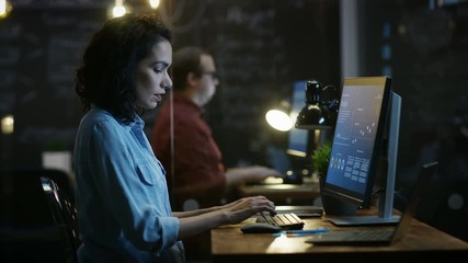 Wall Mural - Stressed, Overworked Female Financier Holds Her Head in Hands while Working on a Personal Computer. In the Background Creative Office. RED EPIC-W 8K Camera.