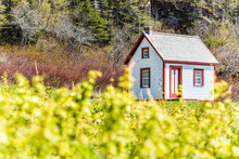 Old Vintage White And Red Wooden House Cottage On Hill In Idyllic Rural Countryside Backyard Garden With Blackberry, Raspberry, Black Currants On Bonaventure Island In Quebec, Canada In Summer