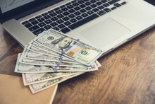 Money, US Dollar Bills, On Laptop Computer At Working Table
