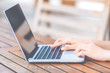 © apichon_tee - Woman hands working with laptop computer in cafe in the garden in front of the office.