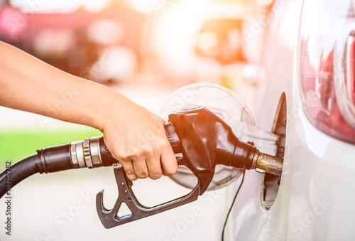 Fotografía Closeup of woman hand holding a fuel pump at a station.
