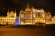 Budynek węgierskiego parlamentu w Budapeszcie, w nocy, podświetlony, choinka bożonarodzeniowa przed budynkiem