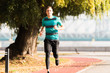 Handsome young man wearing sportswear and running at quay during autumn