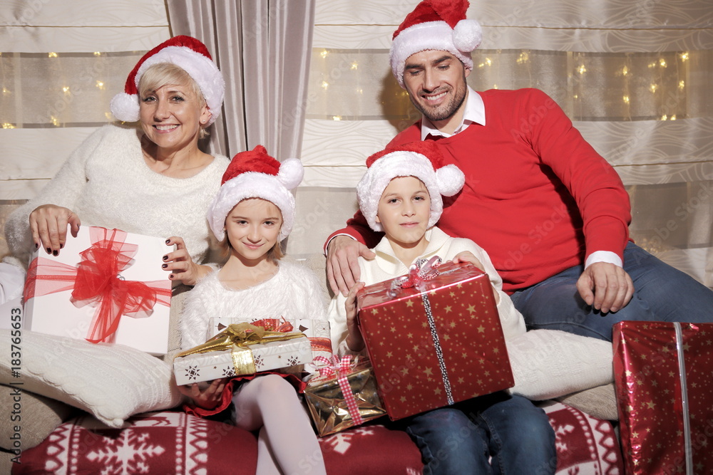 Rodzina na kanapie z prezentami podczas Świąt Bożego Narodzenia - obrazy, fototapety, plakaty 