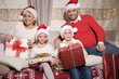Rodzina na kanapie z prezentami podczas Świąt Bożego Narodzenia
