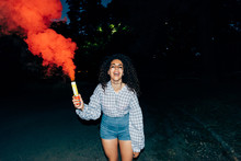 Woman Holding Flare In Park At Night