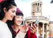 © Connect Images - Two young stylish women looking at smartphone, London, UK