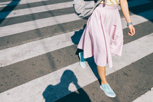 Young Woman In A Pink Skirt And Sneakers