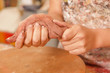 Closeup of woman ceramist hands working on sculpture on wooden table in workshop