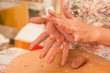 Closeup of woman ceramist hands working on sculpture on wooden table in workshop