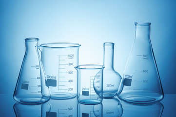 Wall Mural - laboratory glassware set with reflections on blue background