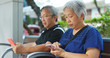 © leungchopan - Retired couple use of mobile phone at street