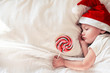 © Angelina - Santa is sleeping in a crib with a lollipop in his hand
