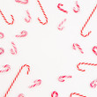 © artifirsov - Frame of traditional Christmas candy cane on white background. Flat lay holiday concept.