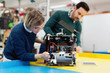 © NDABCREATIVITY - Young students of robotics preparing robot for testing