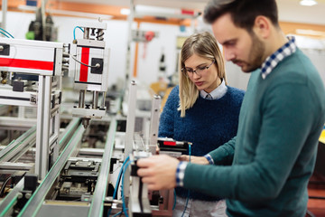 Two young handsome engineers working on electronics components