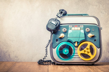 Poster - Retro old reel to reel tape recorder and headphones front concrete wall background. Vintage instagram style filtered photo