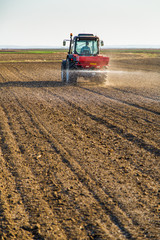 Farmer fertilizing arable land with nitrogen, phosphorus, potassium fertilizer