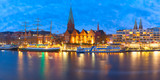 Fototapeta Paryż - Embankment of the Weser River and Protestant Lutheran Saint Martin Church in the old town of Bremen, Germany. Night panoramic view.