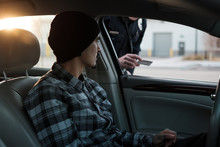 A Police Officer Inspects The Licence Of A Driver During A Traffic Stop