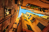 Fototapeta Uliczki - Traditional houses in a narrow street in Genoa, Italy