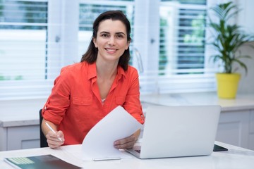 Woman writing on paper at home