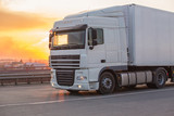 Fototapeta  - truck goes on highway on sunset