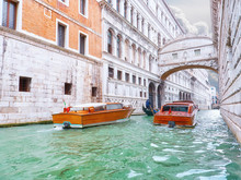 Traditional Boats Taxi Passing Over Bridge Of Sighs In Venice