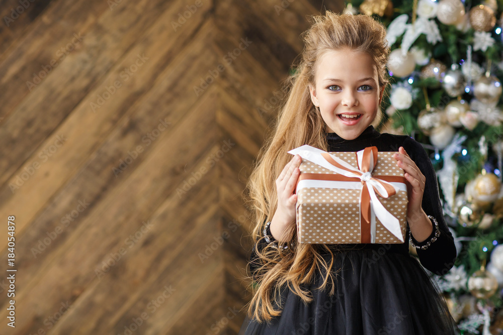 Little cute girl in black dress with a christmas present Stock Photo ...