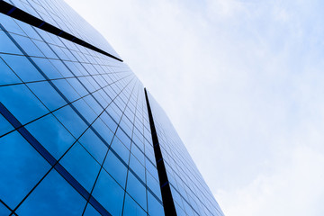 Bottom view of office building window close up with sunrise, reflection and perspective.