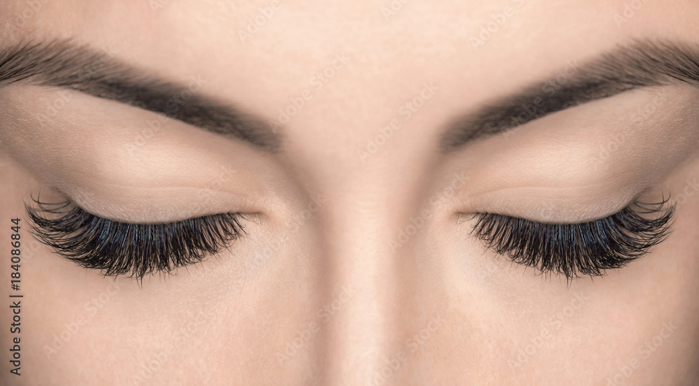 Eyelash extension procedure. Beautiful Woman with long lashes in a beauty salon. - obrazy, fototapety, plakaty 