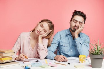 portrait tired crew of office workers sit at table, fall asleep after working long hours on preparin