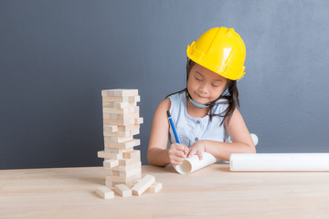 Young asian Thai girl kid in yellow safety helmet