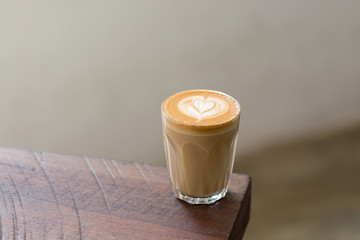 Wall Mural - A Cup of Piccolo latte coffee with latte art on the wooden table background.