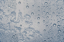 Multiple Water Drops With Some Frozen Snow On A Transparent Glass Window. Clean Background.