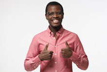 Closeup Of Young Optimistic Afrcian American Business Man Isolated On Grey Background Showing Thumps Up With Positive Emotions Of Content And Happiness. Concept Of Recommendation
