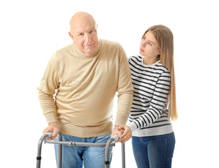 Wall Mural - Young woman and her elderly grandfather with walking frame on white background