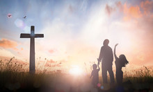 Family Worship Concept: Silhouette Father Mother And Son Looking For The Cross On Autumn Sunrise Background.