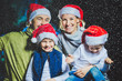 © Michael - Portrait of friendly family in Santa caps looking at camera on Christmas evening
