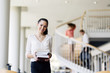 © NDABCREATIVITY - Beautiful woman holding books in a library
