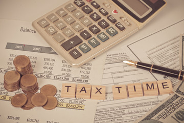 wording tax and calculator with tax documents and money on table. Tax concept.