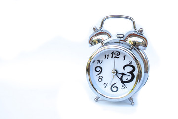 Close up silver alarm clock isolated on white background. (Selective focus)