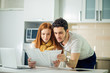 © alfa27 - cheerful young couple calculating their bills at home