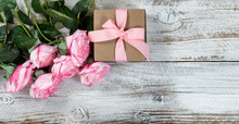 Six Pink Roses And Gift On Rustic White Wooden Background