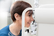 © serafino - Smiling Woman Patient Having a refractor Exam / eye Doctor is doing a Eyeglass prescription a patient during a refraction test /optometrist in eyes clinic is checking the retinoscopy diagnostic