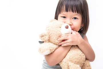 Asian cute little child girl hugging teddy bear isolated on white background.